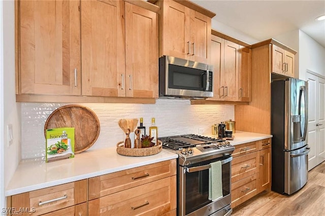 4563 Centaurus Cir, Naples, FL 34120 - kitchen featuring appliances with stainless steel finishes, light wood-style flooring, backsplash, light countertops, and light brown cabinetry