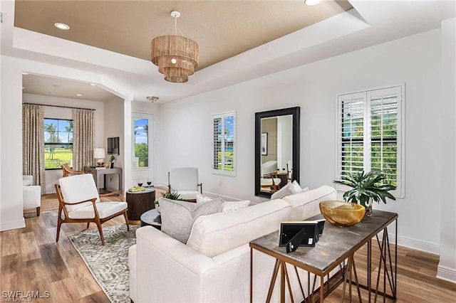 4563 Centaurus Cir, Naples, FL 34120 - living area featuring a raised ceiling, wood finished floors, recessed lighting, and a chandelier