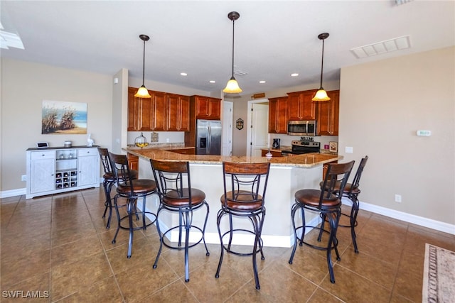 3606 Whippoorwill Blvd, Punta Gorda, FL 33950 - kitchen featuring appliances with stainless steel finishes, dark tile patterned flooring, recessed lighting, a breakfast bar area, and light stone counters