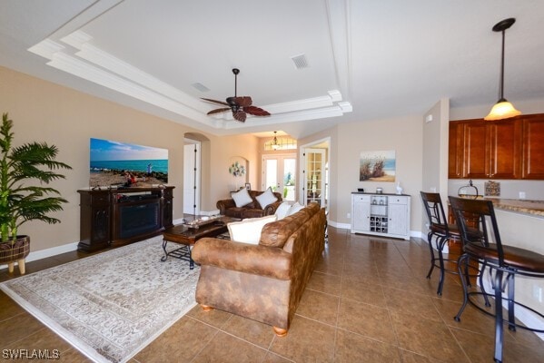 3606 Whippoorwill Blvd, Punta Gorda, FL 33950 - tiled living room featuring a tray ceiling, ceiling fan, and arched walkways