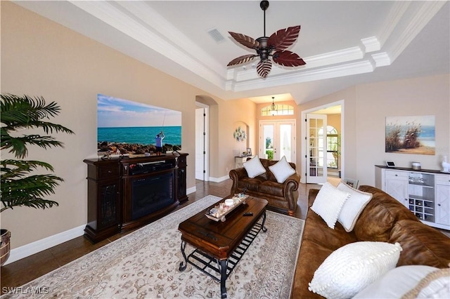 3606 Whippoorwill Blvd, Punta Gorda, FL 33950 - living room featuring a tray ceiling, crown molding, arched walkways, french doors, and a ceiling fan