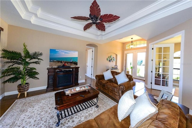 3606 Whippoorwill Blvd, Punta Gorda, FL 33950 - living area featuring a tray ceiling, a fireplace, ornamental molding, french doors, and arched walkways