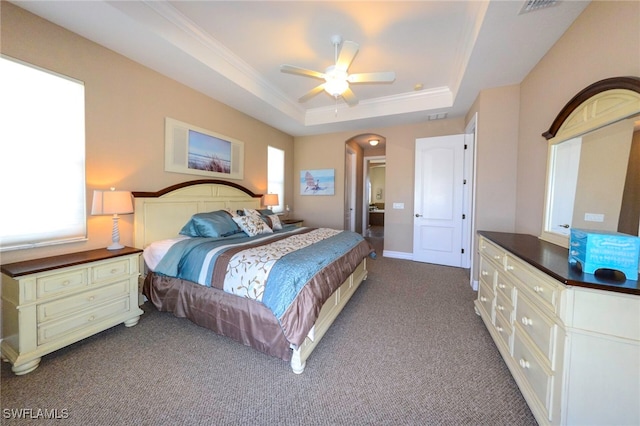 3606 Whippoorwill Blvd, Punta Gorda, FL 33950 - carpeted bedroom featuring multiple windows, a tray ceiling, crown molding, arched walkways, and a ceiling fan