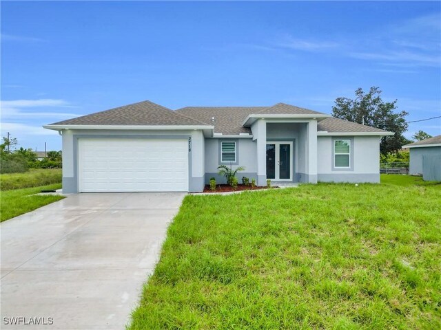 2718 42nd St W, Lehigh Acres, FL 33971 - view of front of house featuring french doors, stucco siding, an attached garage, a front lawn, and driveway