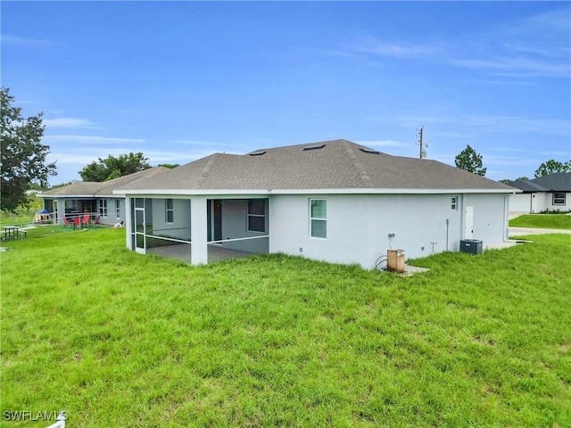 2718 42nd St W, Lehigh Acres, FL 33971 - back of property featuring a sunroom, a yard, a shingled roof, and stucco siding