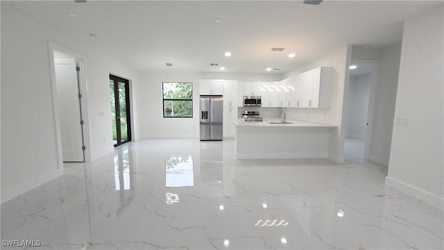 3124 40th St SW, Lehigh Acres, FL 33976 - kitchen with stainless steel appliances, light marble finish flooring, white cabinets, a peninsula, and light countertops