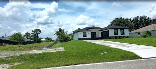 3124 40th St SW, Lehigh Acres, FL 33976 - view of front facade featuring concrete driveway, an attached garage, and a front lawn