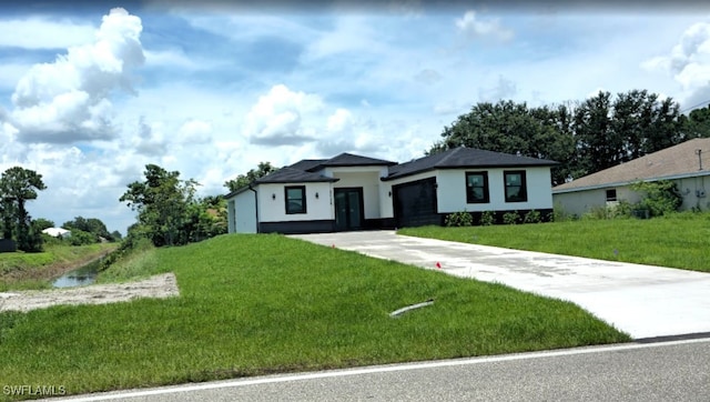 3124 40th St SW, Lehigh Acres, FL 33976 - view of front of home with driveway, a garage, a front lawn, and stucco siding