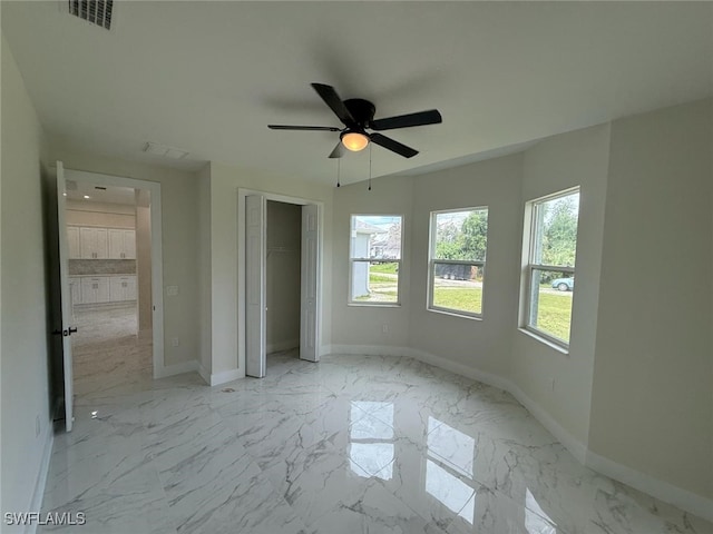 6050 Langdon Ave, Fort Myers, FL 33905 - unfurnished bedroom with multiple windows, light marble finish flooring, and a closet