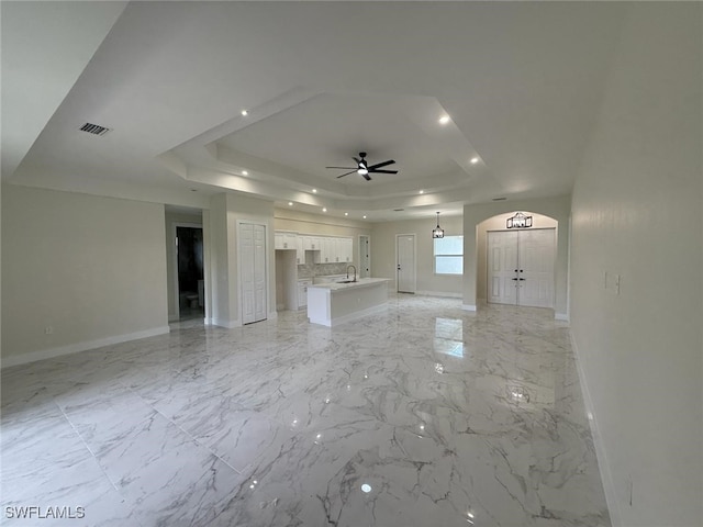 6050 Langdon Ave, Fort Myers, FL 33905 - unfurnished living room with a raised ceiling, ceiling fan, recessed lighting, and light marble finish flooring
