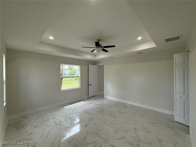 6050 Langdon Ave, Fort Myers, FL 33905 - unfurnished bedroom with a tray ceiling, recessed lighting, light marble finish floors, and a ceiling fan