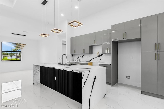2813 24th St W, Lehigh Acres, FL 33971 - kitchen featuring gray cabinets, light marble finish floors, modern cabinets, decorative light fixtures, and a towering ceiling