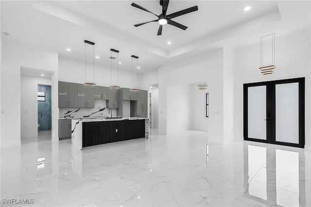 2813 24th St W, Lehigh Acres, FL 33971 - kitchen with gray cabinets, a raised ceiling, a towering ceiling, ceiling fan, and recessed lighting