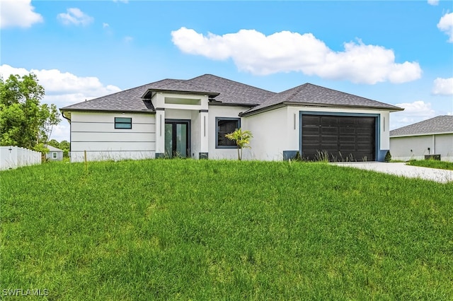 2813 24th St W, Lehigh Acres, FL 33971 - prairie-style house with a garage, driveway, stucco siding, a shingled roof, and french doors