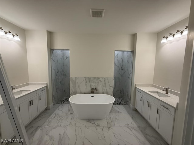 3832 Insdale St, Fort Myers, FL 33905 - full bath featuring two vanities, marble finish flooring, a freestanding tub, a wainscoted wall, and tile walls
