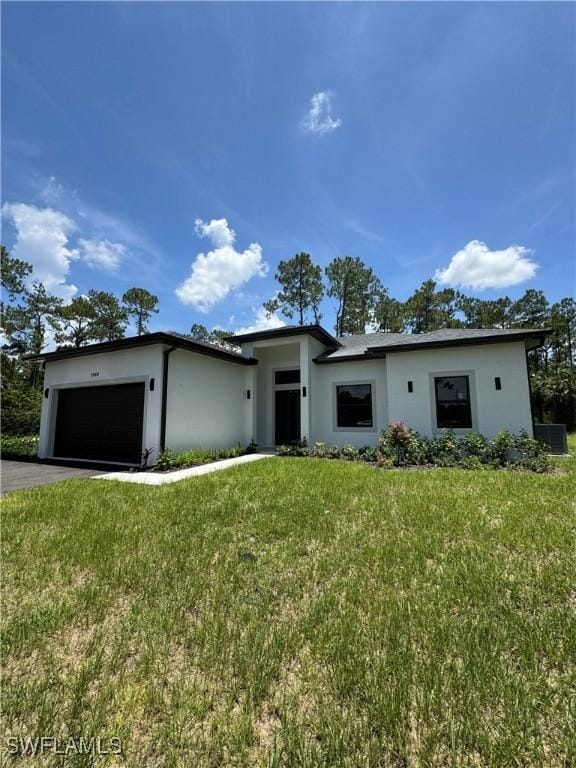 2660 18th Ave NE, Naples, FL 34120 - view of front of home with a garage, stucco siding, driveway, and a front yard