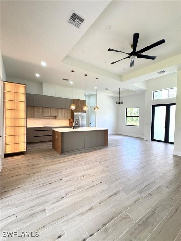 2660 18th Ave NE, Naples, FL 34120 - kitchen with stainless steel refrigerator with ice dispenser, modern cabinets, light countertops, open floor plan, and a large island