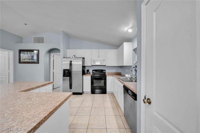 3031 36th St SW, Lehigh Acres, FL 33976 - kitchen with stainless steel appliances, lofted ceiling, white cabinetry, light tile patterned floors, and light countertops
