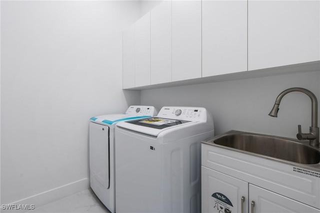 13454 Ingraham Blvd, Port Charlotte, FL 33981 - washroom featuring separate washer and dryer, light marble finish floors, and cabinet space