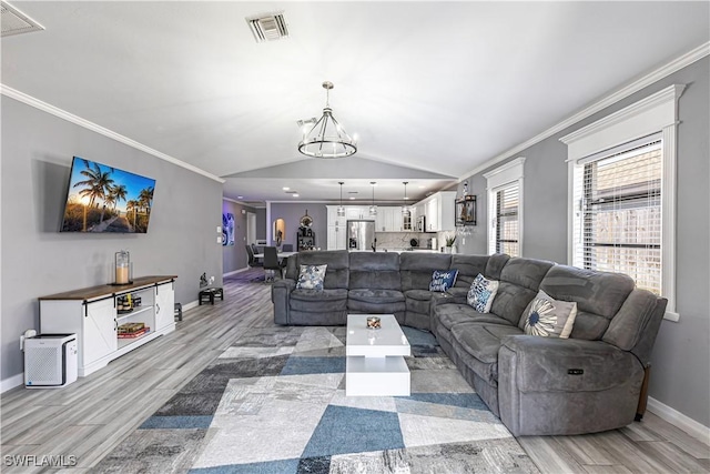 754 105th Ave N, Naples, FL 34108 - living room featuring light wood finished floors, a chandelier, ornamental molding, and lofted ceiling