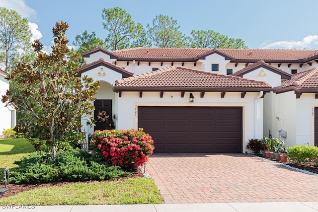 7907 Bristol Cir, Naples, FL 34120 - mediterranean / spanish home featuring an attached garage, decorative driveway, stucco siding, and a tiled roof