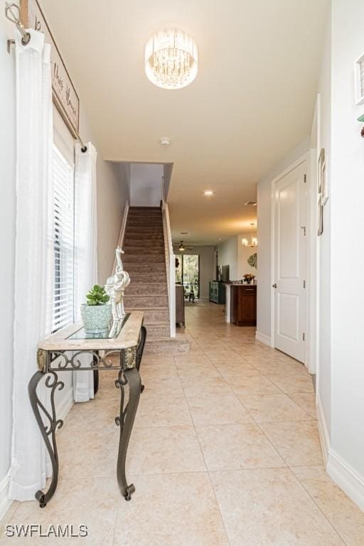 7907 Bristol Cir, Naples, FL 34120 - hall with stairs, a chandelier, and light tile patterned floors