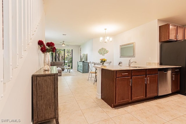 7907 Bristol Cir, Naples, FL 34120 - kitchen with stainless steel dishwasher, light tile patterned flooring, light countertops, and a peninsula
