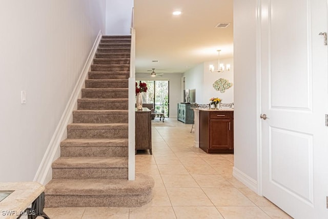 7907 Bristol Cir, Naples, FL 34120 - staircase featuring tile patterned flooring, recessed lighting, a ceiling fan, and a chandelier