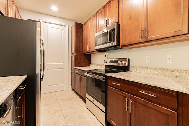 7907 Bristol Cir, Naples, FL 34120 - kitchen featuring appliances with stainless steel finishes, light tile patterned flooring, recessed lighting, and light stone counters