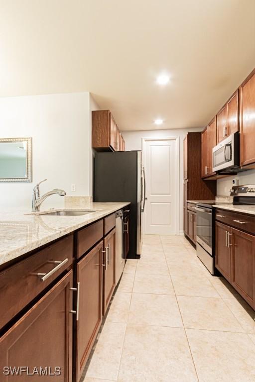 7907 Bristol Cir, Naples, FL 34120 - kitchen with appliances with stainless steel finishes, light stone counters, light tile patterned floors, and recessed lighting