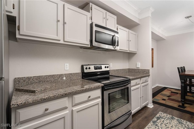 11500 Villa Grand Unit 310, Fort Myers, FL 33913 - kitchen featuring stainless steel appliances, ornamental molding, dark wood finished floors, white cabinets, and dark stone counters