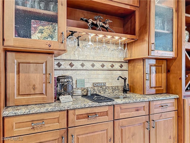 24454 Nova Ln, Punta Gorda, FL 33980 - kitchen featuring decorative backsplash, light stone countertops, and glass insert cabinets