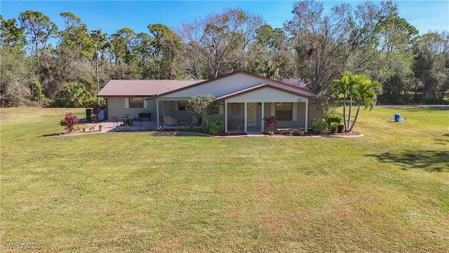 24454 Nova Ln, Punta Gorda, FL 33980 - rear view of house featuring a yard, a patio, a sunroom, and view of scattered trees