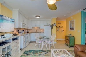 7360 Estero Blvd Unit 703, Fort Myers Beach, FL 33931 - kitchen with crown molding, white appliances, white cabinets, tasteful backsplash, and light countertops