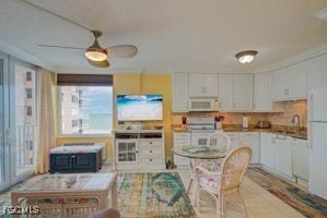 7360 Estero Blvd Unit 703, Fort Myers Beach, FL 33931 - kitchen with white cabinetry, a ceiling fan, and white appliances