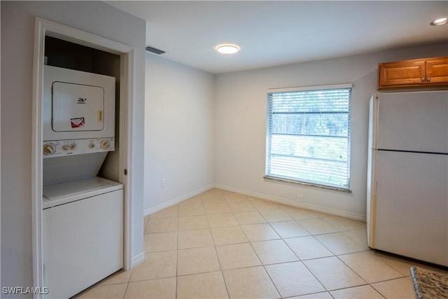 180 Cypress Way E Unit B212, Naples, FL 34110 - laundry area with stacked washer / dryer, light tile patterned flooring, and recessed lighting