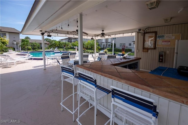 180 Cypress Way E Unit B212, Naples, FL 34110 - view of patio / terrace featuring a bar and a community pool