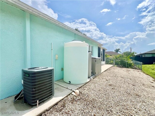 304 NW 22nd Ave, Cape Coral, FL 33993 - view of side of home with a cooling unit and stucco siding