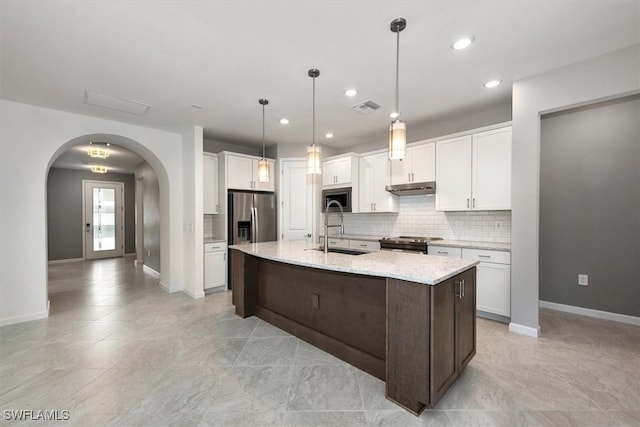 16569 Windsor Way, Alva, FL 33920 - kitchen featuring under cabinet range hood, appliances with stainless steel finishes, arched walkways, white cabinetry, and recessed lighting