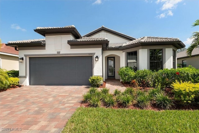 16569 Windsor Way, Alva, FL 33920 - mediterranean / spanish house with decorative driveway, a garage, stucco siding, and a tiled roof