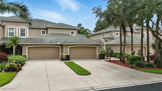 3425 Laurel Greens Ln S Unit 203, Naples, FL 34119 - view of front of house featuring stucco siding, concrete driveway, a garage, and a tiled roof