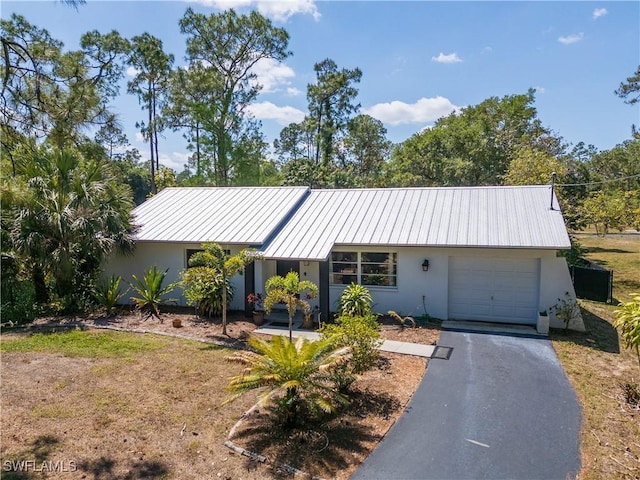 5870 Star Grass Ln, Naples, FL 34116 - ranch-style house with an attached garage, stucco siding, and a metal roof