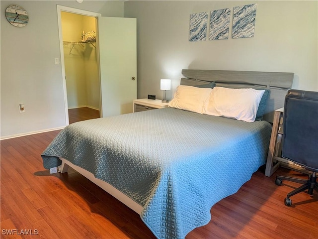 5870 Star Grass Ln, Naples, FL 34116 - bedroom with wood finished floors, a walk in closet, and a closet