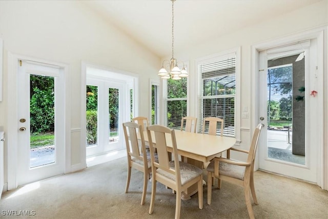 2457 Dorset Ct, Naples, FL 34112 - dining space with light colored carpet, plenty of natural light, a chandelier, and vaulted ceiling