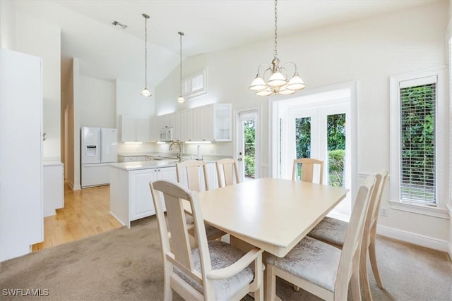 2457 Dorset Ct, Naples, FL 34112 - dining area with light carpet, healthy amount of natural light, a chandelier, and high vaulted ceiling
