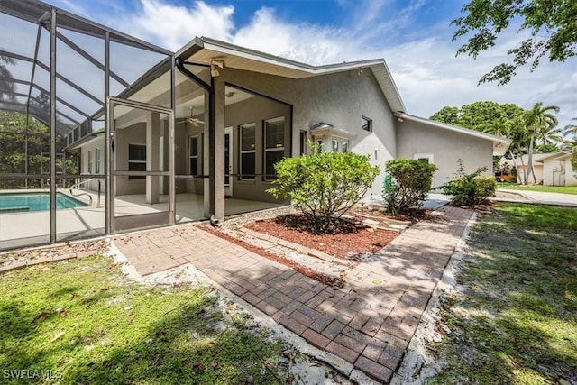 2457 Dorset Ct, Naples, FL 34112 - rear view of property with stucco siding, a patio, a ceiling fan, an outdoor pool, and glass enclosure