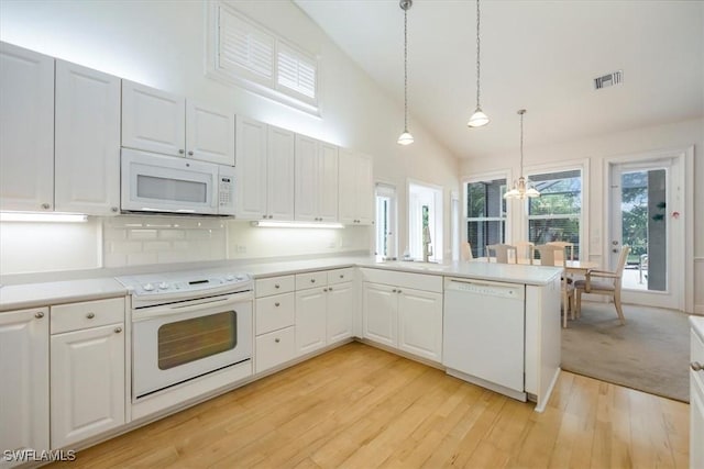 2457 Dorset Ct, Naples, FL 34112 - kitchen featuring white appliances, a chandelier, a peninsula, light countertops, and light wood-style flooring