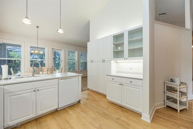 2457 Dorset Ct, Naples, FL 34112 - kitchen featuring white dishwasher, light wood-style floors, white cabinets, glass insert cabinets, and vaulted ceiling