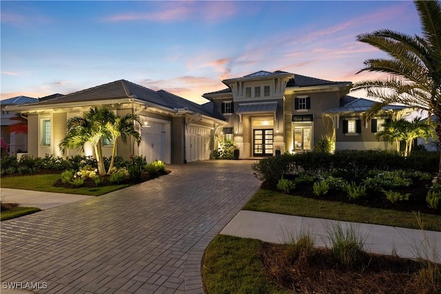 8923 Nevis Way, Naples, FL 34112 - view of front of property with french doors, decorative driveway, a garage, and stucco siding
