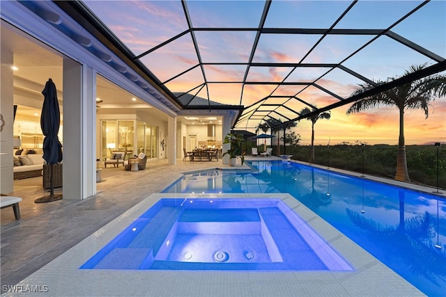 8923 Nevis Way, Naples, FL 34112 - pool at dusk with outdoor lounge area, a patio, a pool with connected hot tub, and a lanai